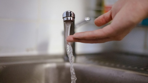 вода из крана течет на ладонь