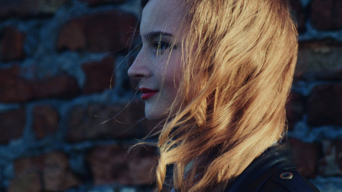 Девушка на фоне кирпичной стены