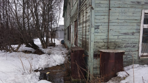 лужа возле старого деревянного дома