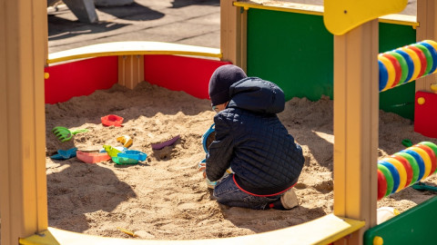 ребенок играет в песочнице