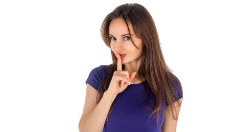 Девушка прижимает палец ко рту