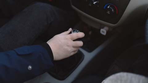 женщина переключает скорость в машине
