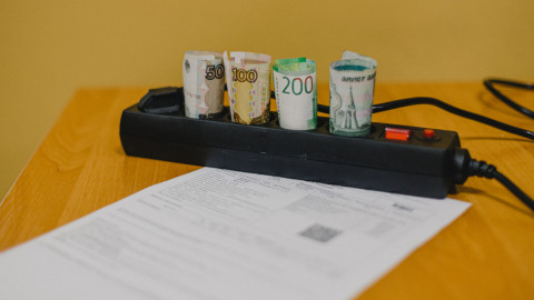 свернутые купюры и счет за ЖКХ