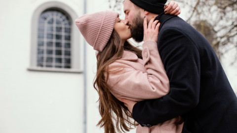 Влюбленная пара целуется на улице.