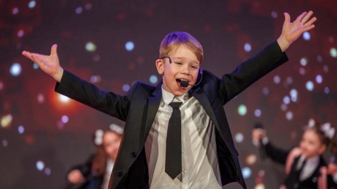 мальчик поет на сцене