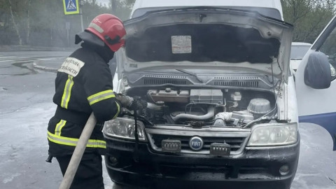пожарный тушит грузовой автомобиль