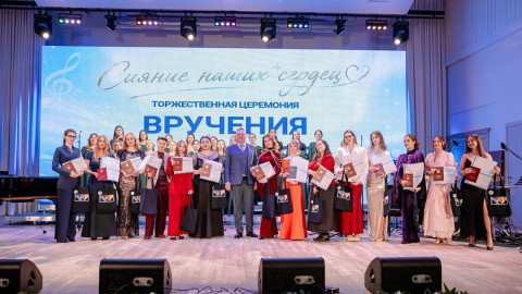 выпускники с дипломами на сцене