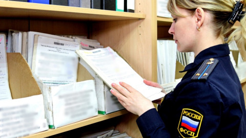 судебный пристав листает дело
