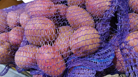 картофель в сетке на прилавке