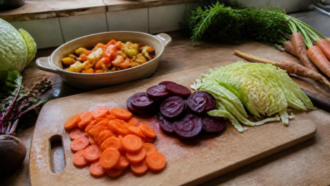 Нарезанные сезонные овощи на деревянной доске на кухне