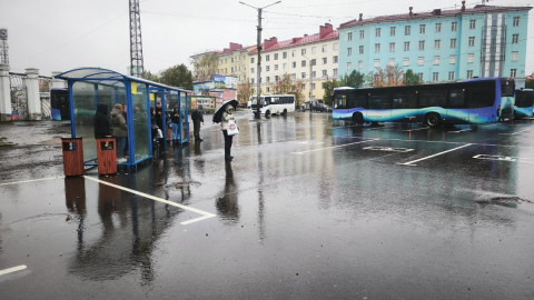 люди стоят в остановочном павильоне