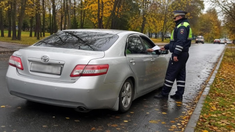 Инспектор ГИБДД останавливает автомобиль осенью