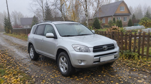 Чистый кроссовер Toyota RAV4 на дачной дороге в октябре
