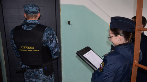 приставы стоят возле квартиры