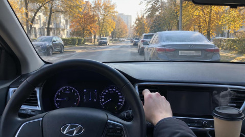 Водитель проверяет работу печки в автомобиле осенним утром