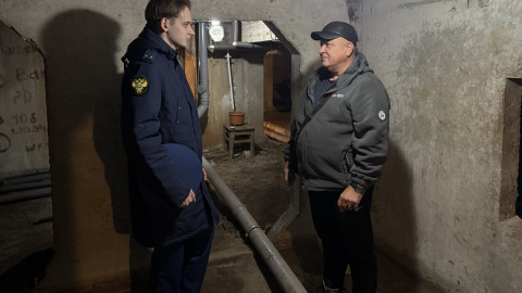 прокурор с мужчиной стоят в подвале